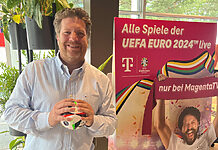 Telekom setzt weiter auf PLAZAMEDIA – auch bei der Fußball-EM Arnim Butzen, Deutsche Telekom, vor einem Fußball-EM-Plakat